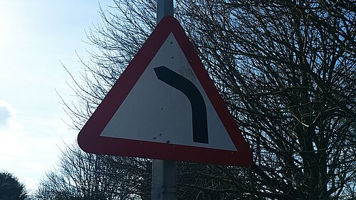 "Road bends to right ahead" road traffic warning sign