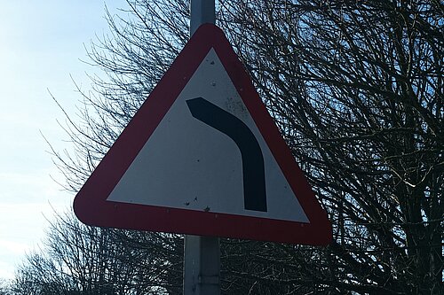 "Road bends to right ahead" road traffic warning sign